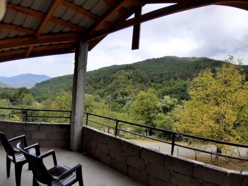 a balcony with chairs and a view of a mountain at Muse House in Ambrolauri