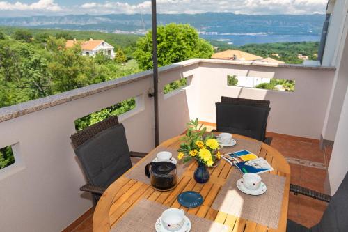 a table with flowers on top of a balcony at Apartments House Risika in Risika