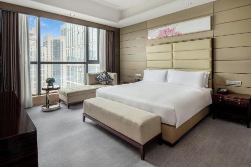 1 dormitorio con cama grande y ventana grande en Crowne Plaza Shenzhen Longgang City Centre, an IHG Hotel, en Longgang