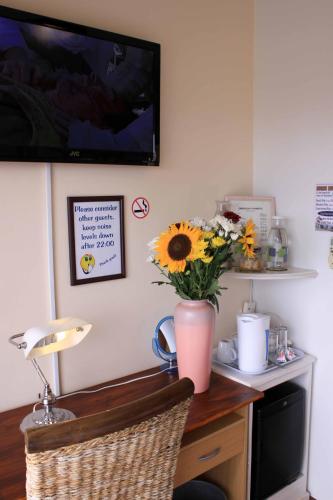 a desk with a vase of sunflowers on it at Blougans B&B in Gansbaai