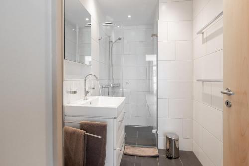 a white bathroom with a sink and a shower at Pranursa in Arosa