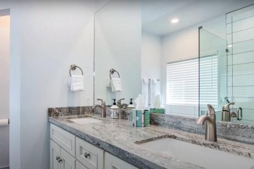 a bathroom with two sinks and a large mirror at THREE TREE VILLA w/ EV Charging in Yucca Valley