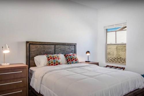 1 dormitorio con 1 cama blanca grande y 2 almohadas en THREE TREE VILLA w/ EV Charging, en Yucca Valley