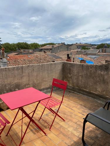 a red chair and a table on a roof at Rooftop vue cité médiévale ! in Carcassonne