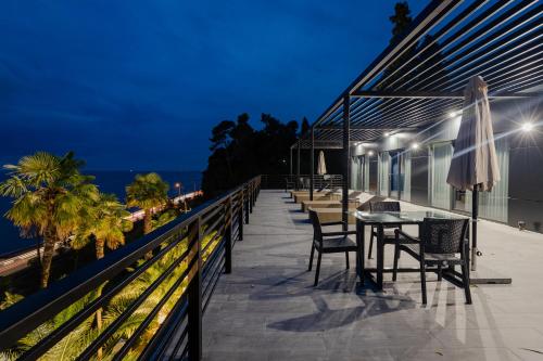 a balcony with a table and chairs at night at House at the Sea in Batumi