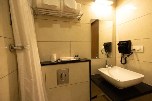 a bathroom with a sink and a mirror at Poornima Regency in Bangalore