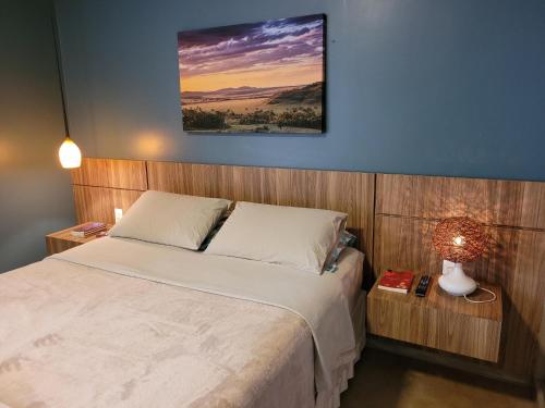 Casa Dharma - Conforto e Silêncio في ألتو بارايسو دي غوياس: غرفة نوم بسرير وصورة على الحائط