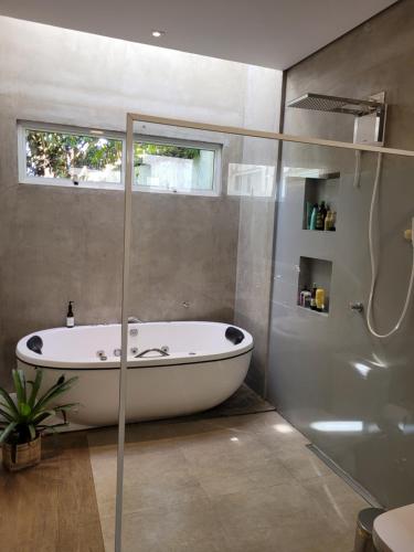 Casa Dharma - Conforto e Silêncio في ألتو بارايسو دي غوياس: حوض استحمام في حمام به نافذة