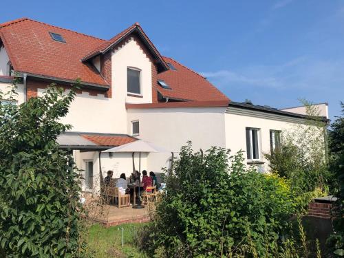 un grupo de personas sentadas en una mesa fuera de una casa en Ferienhaus Erna, en Doberlug-Kirchhain