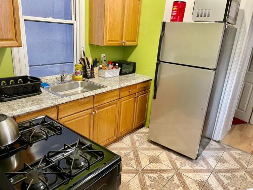 een keuken met een koelkast en een fornuis bij 3 bedrooms 2 stops to Manhattan in Long Island City