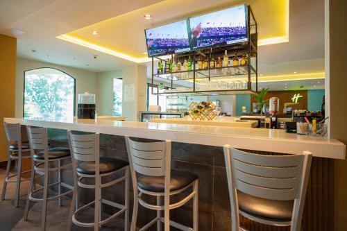 a bar in a restaurant with a tv above it at Holiday Inn Panama Canal by IHG in Panama City