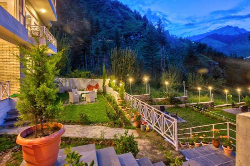 a house with a garden with a view of a mountain at Baan by Snow City Farm in Vashisht