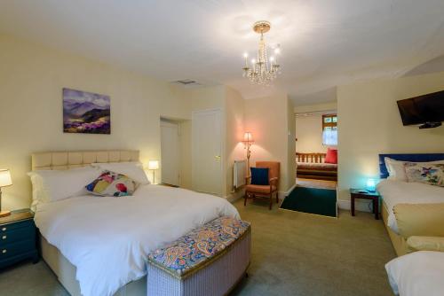 a bedroom with two beds and a chandelier at Pen-Y-Bont Hotel in Tal-y-llyn