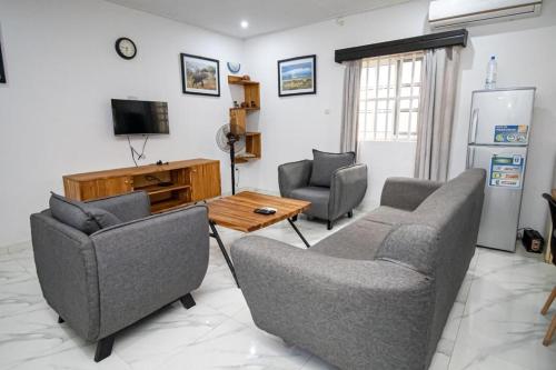 a living room with two chairs and a table and a tv at Villa Damas in Lomé