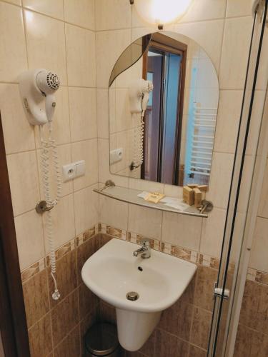 een badkamer met een wastafel en een spiegel bij Agroturystyka w dolinie in Żegiestów
