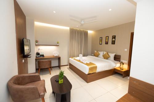 a hotel room with a bed and a desk at Poornima Regency in Bangalore