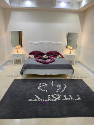 a bedroom with a bed with a black rug at Villa avec piscine in Triffa