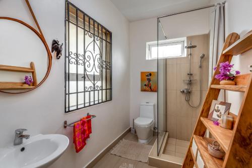 a bathroom with a shower toilet and a sink at Ewange - A Casa Mia in Kampala
