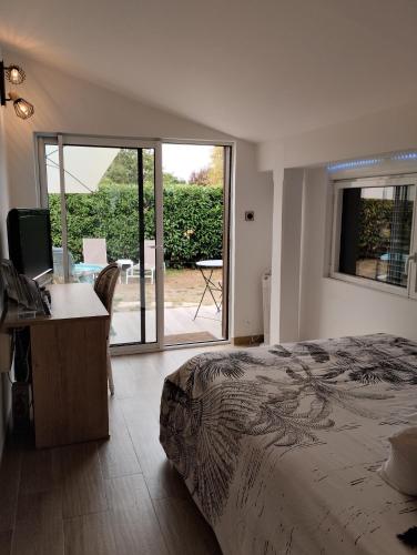 une chambre avec un lit et un bureau avec un ordinateur dans l'établissement L'Atelier Saint-Sulpice entre Bordeaux et St Emilion, à Saint-Sulpice-et-Cameyrac