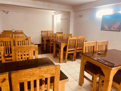 comedor con mesas y sillas de madera en Hotel Solitaire - With Best View of Mountains, en Manali