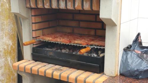 a grill with some meat and other food in it at La Ola de Cantabria in Miengo