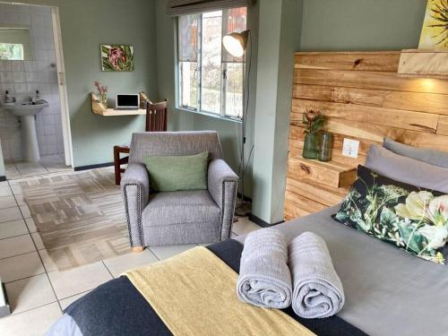 ein Schlafzimmer mit einem Stuhl und einem Bett mit Handtüchern in der Unterkunft Budler Stay, 3 Bedroom, Self Catering apartment in Upington