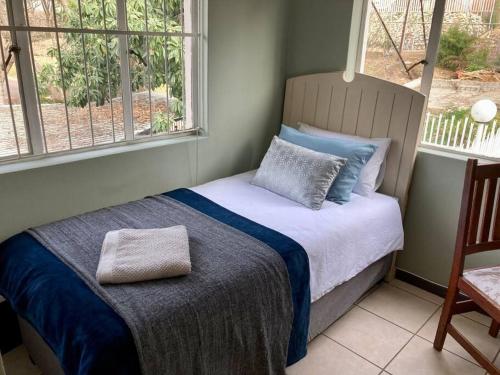 ein Schlafzimmer mit einem Bett und zwei Fenstern in der Unterkunft Budler Stay, 3 Bedroom, Self Catering apartment in Upington