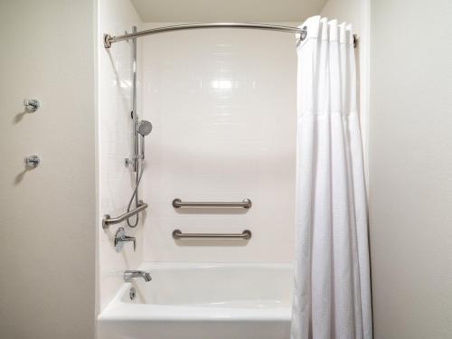 a bathroom with a tub and a shower curtain at Staybridge Suites - Sioux City Southeast by IHG in Sioux City