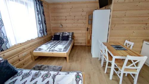 a room with a bed and a table and a desk at Pokoje u Jędragów in Zakopane
