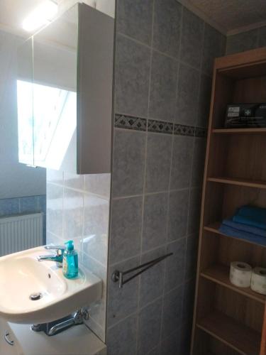 a bathroom with a sink and a shower with a mirror at FewoQuido 2 in Königsee