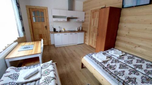 a small room with two beds and a kitchen at Pokoje u Jędragów in Zakopane