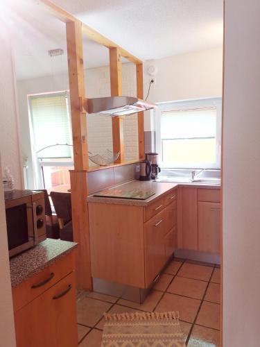 a kitchen with wooden cabinets and a microwave at Ferienwohnung Jasmin in Rust