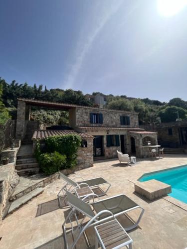 um pátio com cadeiras e uma piscina em frente a uma casa em A Casa di Furtunatu em Santa-Reparata-di-Balagna