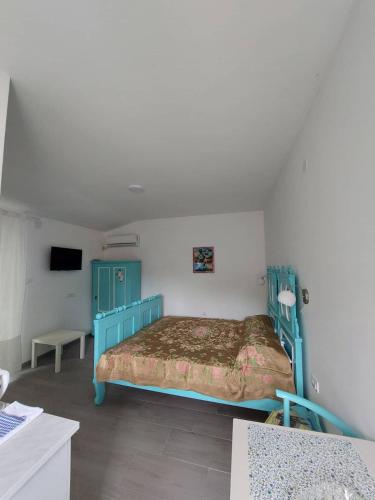 - une chambre avec un lit bleu et une télévision dans l'établissement apartman Vrdničak 2, à Vrdnik
