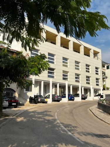 un bâtiment blanc avec des voitures garées devant lui dans l'établissement Villa Lory, à Makarska