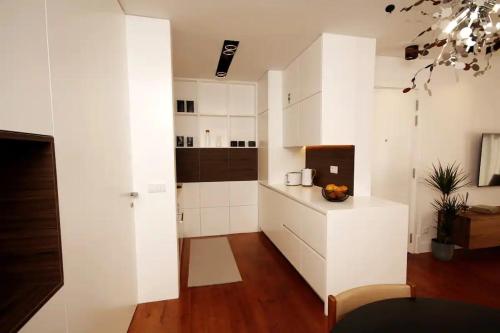 uma cozinha branca com armários brancos e uma mesa em Timeless Ambassador -Belém em Lisboa