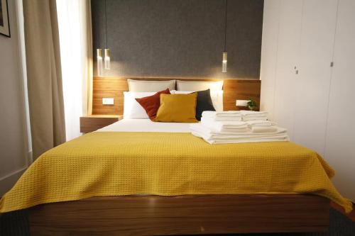 a bedroom with a large bed with a yellow blanket at Timeless Ambassador -Belém in Lisbon