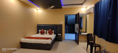 a bedroom with a bed and a chair in a room at Hotel Mari Aai Residency in Navi Mumbai
