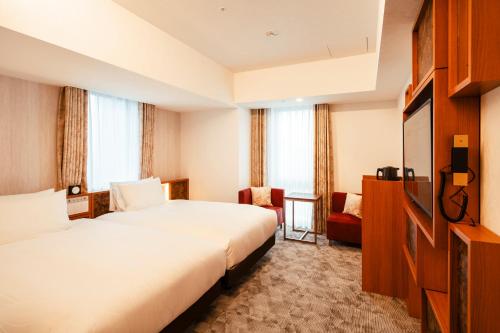 a hotel room with two beds and a television at Keisei Richmond Hotel Tokyo Oshiage in Tokyo