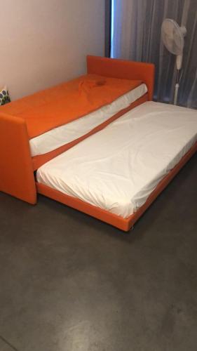 two beds in a bedroom with an orange bed frame at Chromotel self check-in in Mezzovico