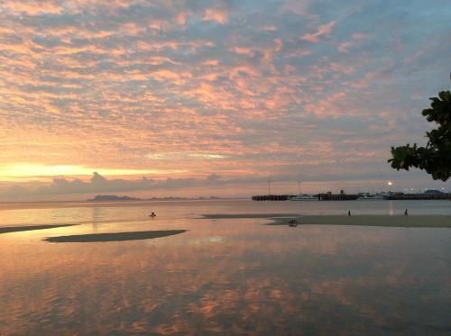 a sunset on a beach with a cloudy sky at Sri Samui in Nathon
