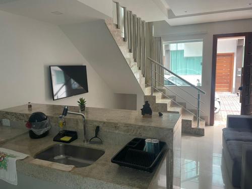 ein Wohnzimmer mit Waschbecken und Treppe in der Unterkunft Apartamento Duplex - a 3 min da Praia apé, Próximo Axé Moi e ToaToa in Porto Seguro