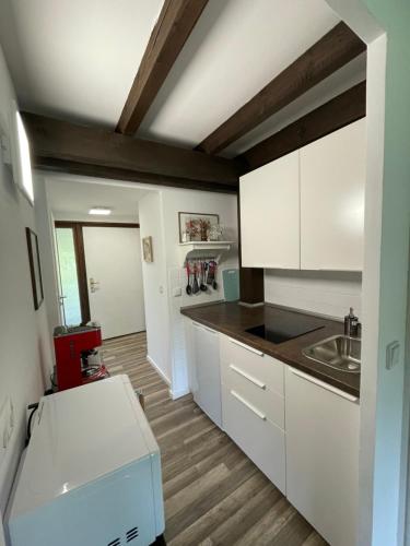 una cocina con armarios blancos y fregadero en Ferienwohnung Studio 5, en Siegsdorf