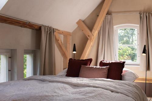 a bedroom with a large bed and two windows at Gutshaus Zarchlin in Zarchlin