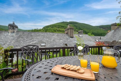 a table with a tray of food and two glasses of orange juice at Gwel y Bryn in Corris