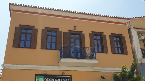 a yellow building with windows and a balcony at Christos Katerina House in Pythagoreio