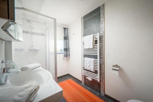 ein Bad mit einer Dusche und einem weißen Waschbecken in der Unterkunft Ferienwohnungen Vordergriess in Hochfilzen