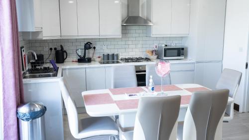 a kitchen with white cabinets and a table and chairs at Doonan Breeze in Donegal