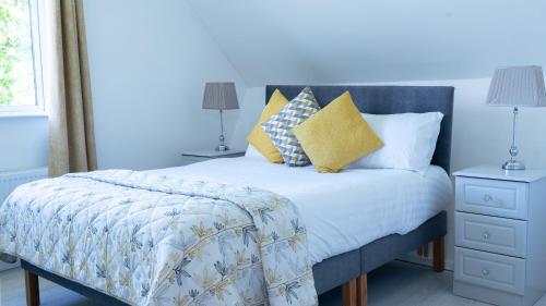 Dormitorio azul con cama con almohadas amarillas en Doonan Breeze en Donegal