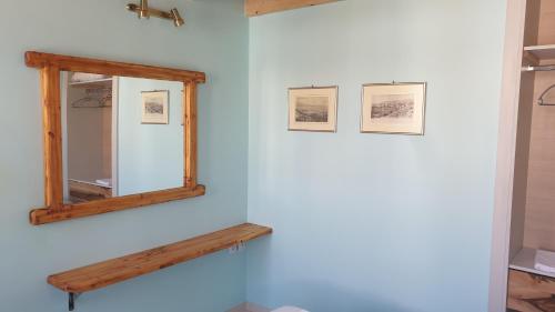 a mirror on a wall with three pictures on it at Christos Katerina House in Pythagoreio